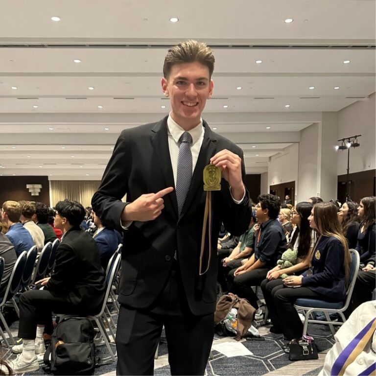 Benjamin Lindall holding a debate medal